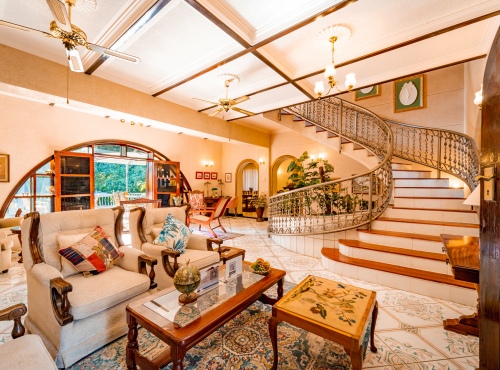 The living area and winding staircase at The Victorian Manor, a luxury bed and breakfast lodge in Victoria Falls, Zimbabwe